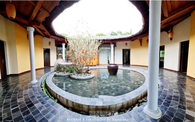 Thiết kế giếng trời trung tâm Nana House Villa, kiến trúc nhà tròn mái tranh, hồ nước và cây xanh bên trong.