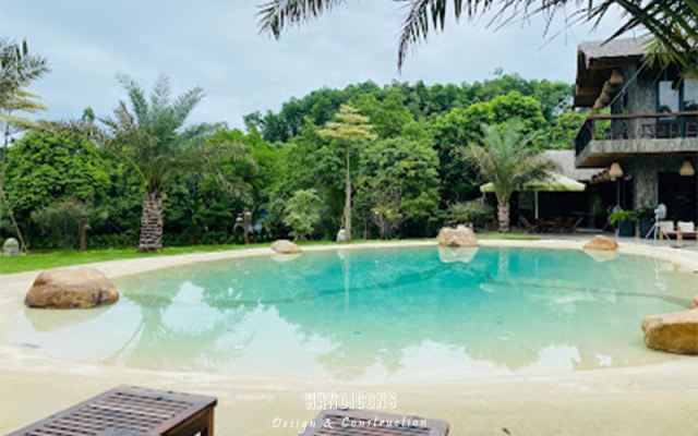 Hồ bơi thiết kế tự nhiên uốn lượn trước khuôn viên biệt thự nghỉ dưỡng hoàn thiện.