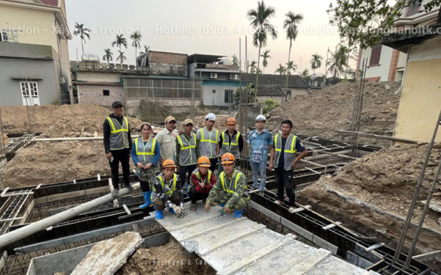 Giám đốc Hanoicons chụp ảnh cùng đội ngũ công nhân trên nền móng công trình, thể hiện cam kết Sứ Mệnh về chất lượng thi công và trách nhiệm với dự án.