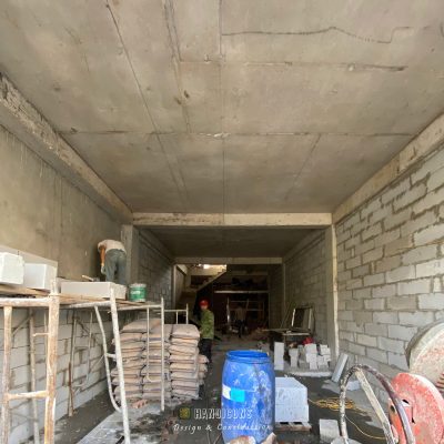 Công nhân xây dựng của Hanoicons đang thi công tường bằng gạch siêu nhẹ AAC tại công trình nhà phố, bên cạnh là các vật tư như xi măng và máy trộn vữa.