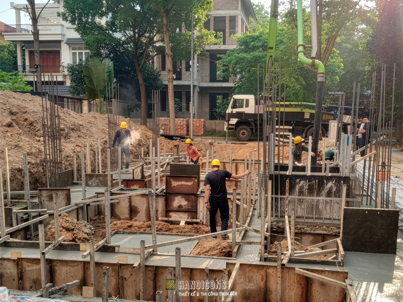 Quy trình thi công đổ bê tông tươi khối lớn cho đài móng bằng xe bơm chuyên dụng trước khi bước vào giai đoạn bảo dưỡng giữ ẩm.