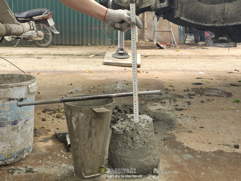 Kỹ sư đo kiểm tra độ sụt bê tông tươi đạt chuẩn kỹ thuật trước khi đổ móng nhà dân dụng.