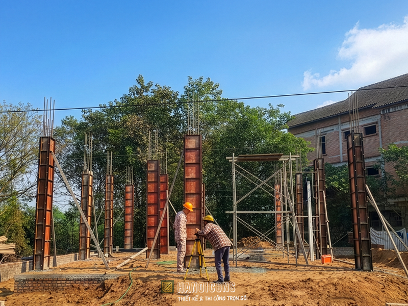 Kỹ sư Hanoicons nghiệm thu độ thẳng đứng của cốp pha bằng máy trắc đạc, đảm bảo quy trình đổ bê tông cột chuẩn kỹ thuật và an toàn.
